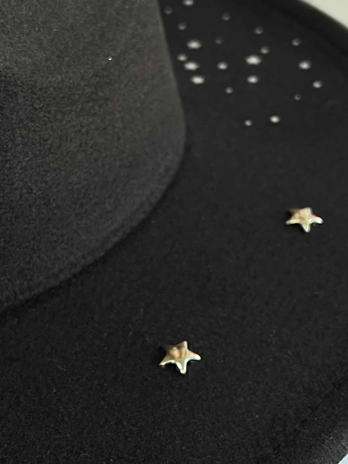 ¡Añade un toque de elegancia y originalidad a tu outfit con Estrella Negra, el sombrero fedora con detalles plateados! Este sombrero es imprescindible para cualquier amante de la moda que busca un toque de sofisticación en su look.