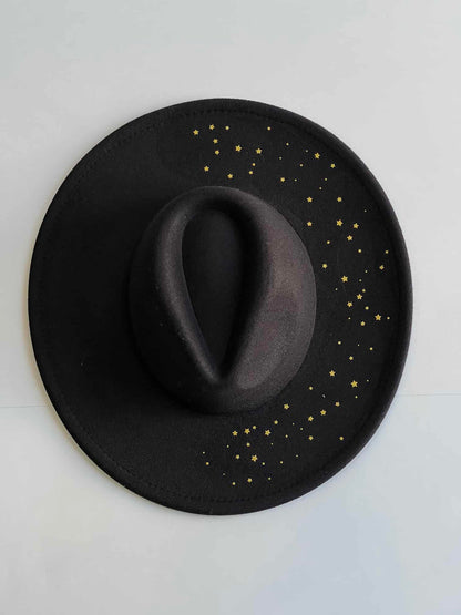 ¡Añade un toque de elegancia y originalidad a tu outfit con Noche Estrellada, el sombrero fedora en negro con detalles dorados! Este sombrero es imprescindible para aquellos que buscan un toque de sofisticación en su look.