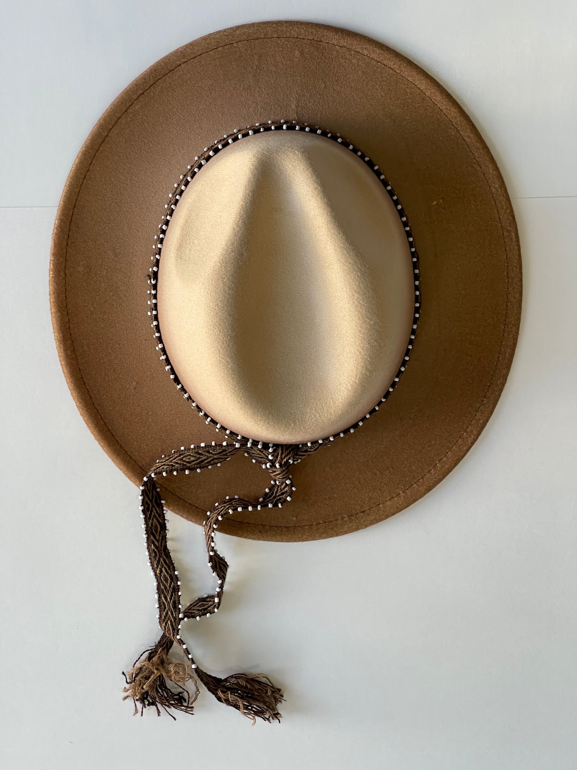 ¡Añade un toque de elegancia y estilo a tu outfit con este hermoso fedora hat en color moca, hecho en Perú! Este sombrero es imprescindible para cualquier amante de la moda, y su diseño de color fade lo hace único y original.